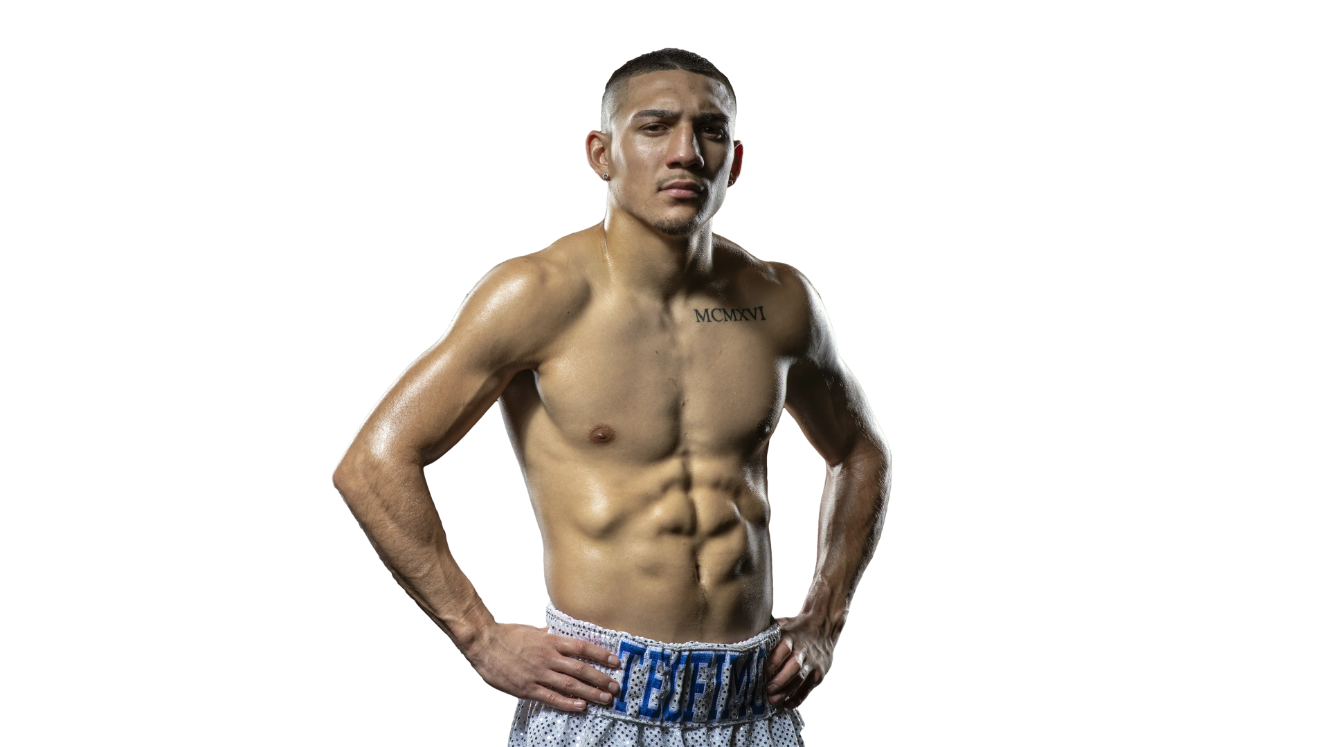 Teofimo Lopez standing shirtless with hands on hips and a focused gaze.