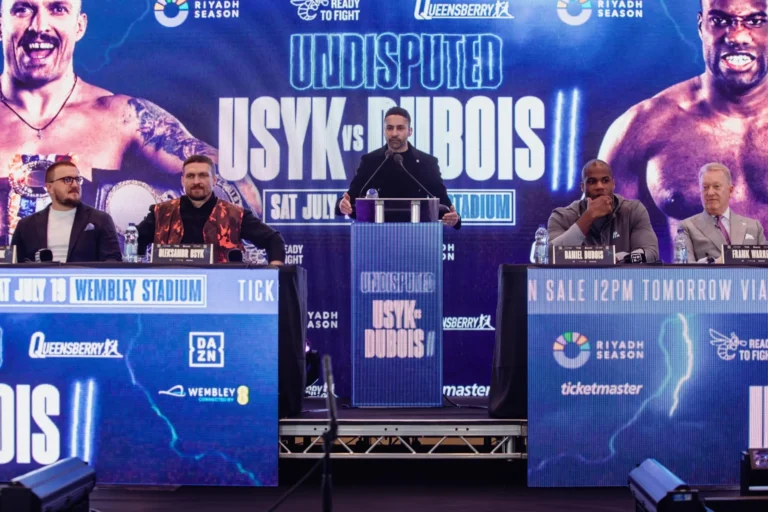 Oleksandr Usyk and Daniel Dubois face off at the Usyk vs Dubois 2 press conference with promotional backdrop at Wembley.